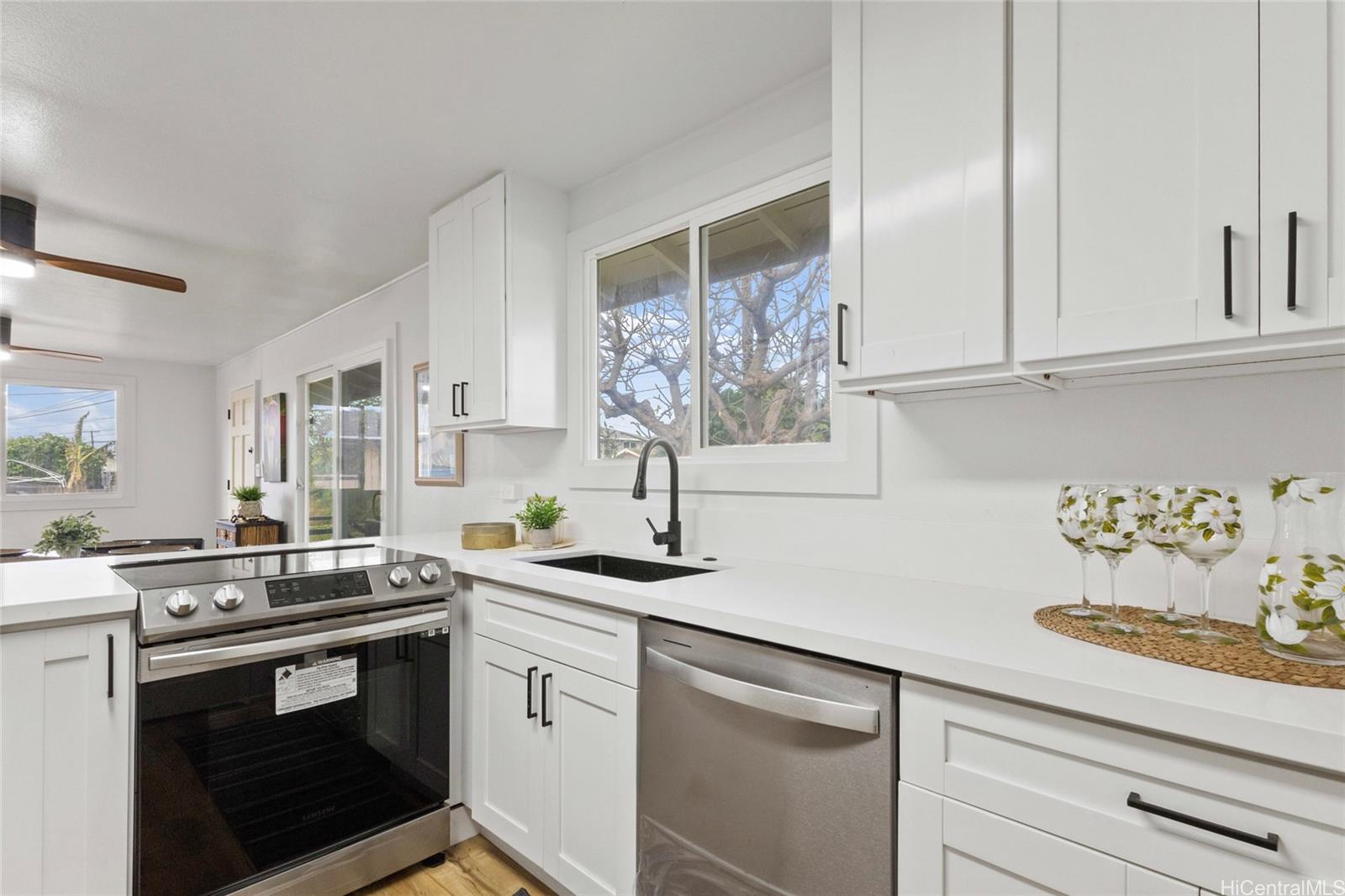 91-433 Ewa Beach Road Ewa Beach, HI 96706 - Photo 11 of 22 a kitchen with stainless steel appliances white cabinets and a stove top oven