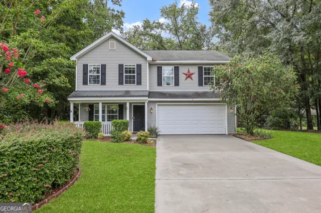 a front view of a house with a yard and trees