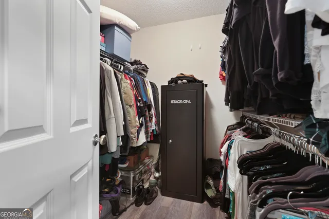 a view of walk in closet with clothes and shoes