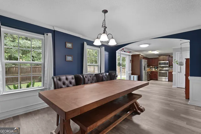 a living room with a table chairs and a large window