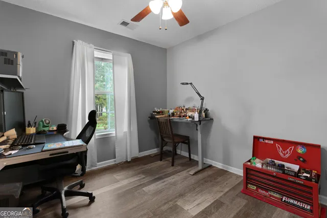 a view of a workspace with furniture and a window