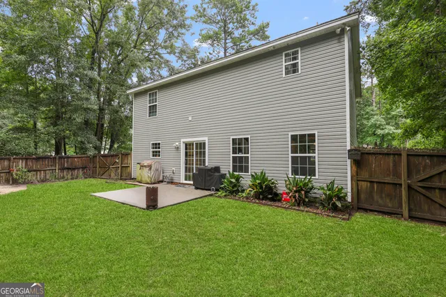 a view of a house with backyard and sitting area