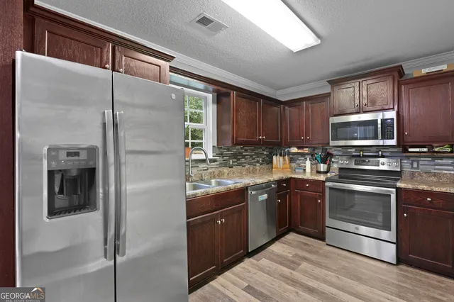 a kitchen with stainless steel appliances granite countertop a refrigerator and a sink