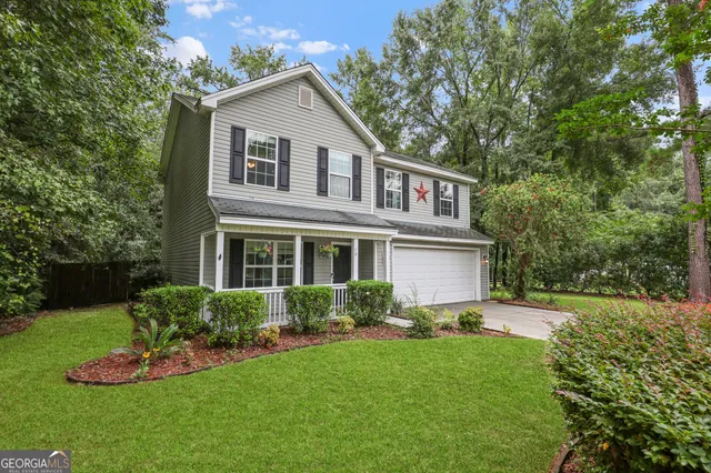 a front view of a house with a yard and trees