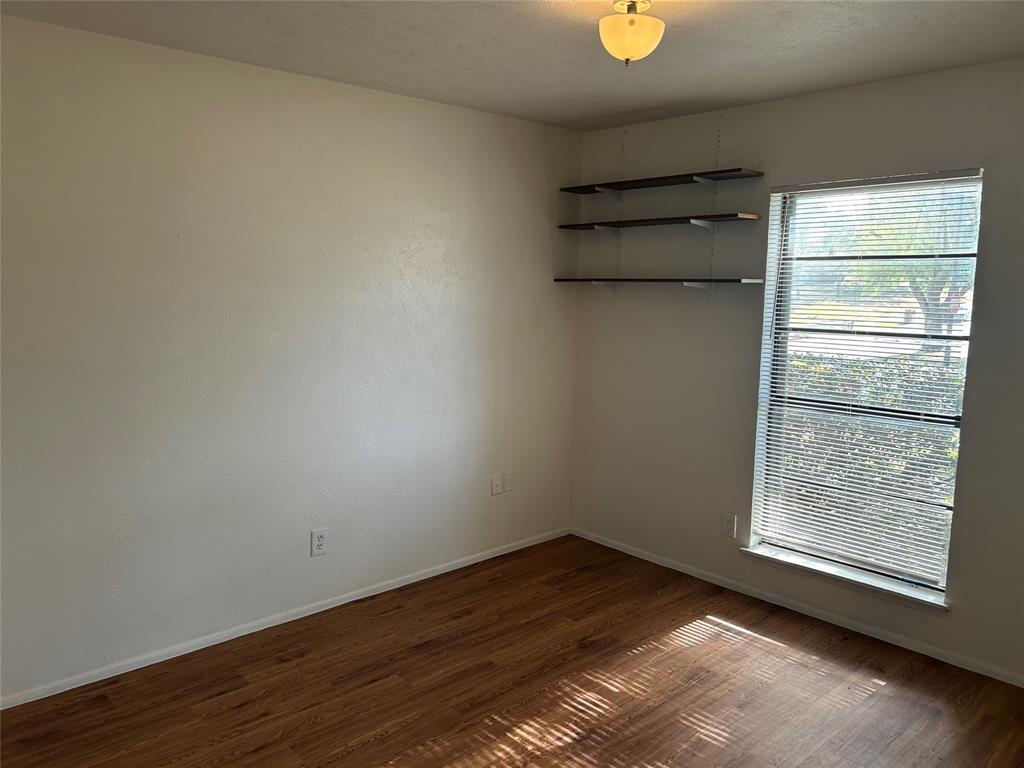 1826 Legend Drive Garland, TX 75040 - Photo 6 of 11 an empty room with wooden floor and windows