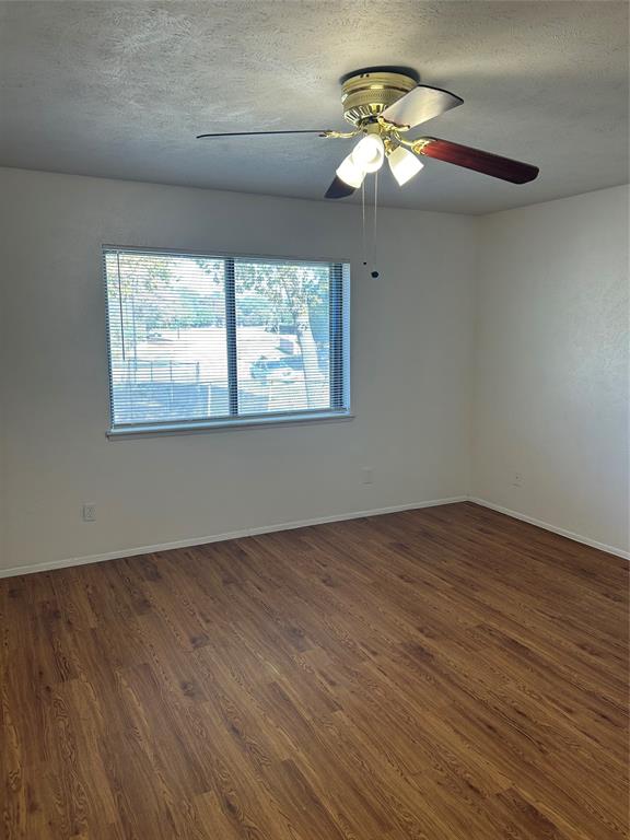 1826 Legend Drive Garland, TX 75040 - Photo 7 of 11 an empty room with wooden floor chandelier fan and windows
