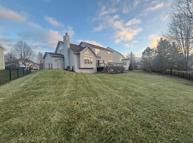 a house that is sitting in the grass with large trees