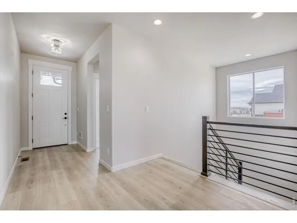a view of empty room with window and wooden floor