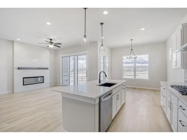 a kitchen with kitchen island a sink appliances wooden floor and a window