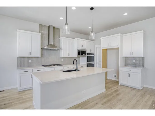 a kitchen with kitchen island a stove a sink a center island and cabinets