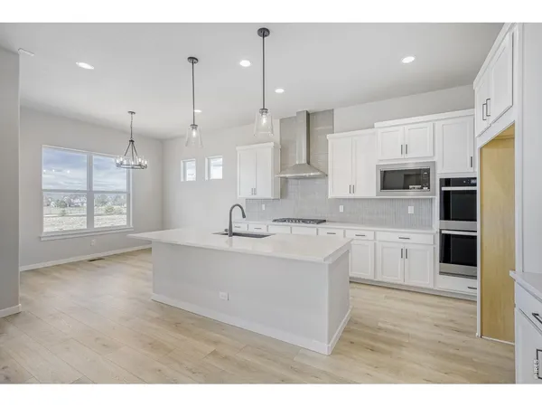a large kitchen with kitchen island a sink stainless steel appliances and cabinets
