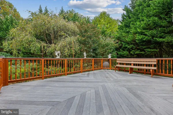 a view of roof deck with wooden floor and fence next to a yard
