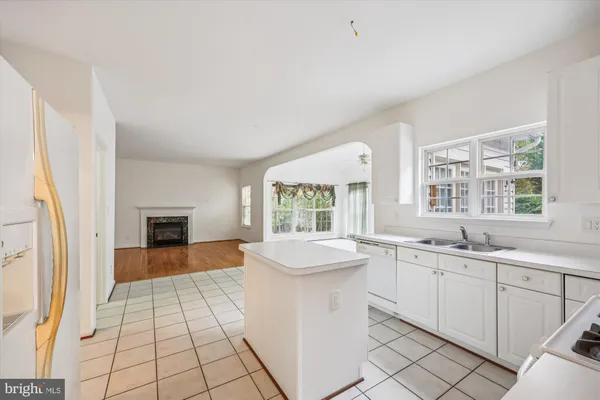 a large white kitchen with a sink and cabinets