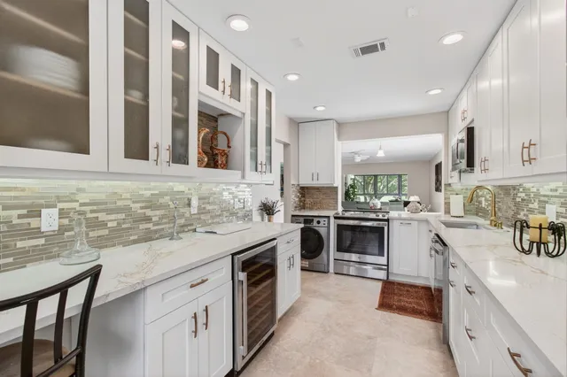 a kitchen with stainless steel appliances granite countertop a stove and more cabinets