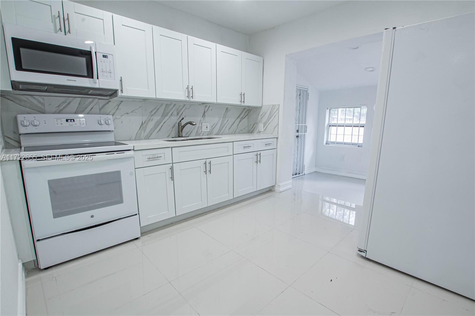 575 Northwest 49th Street Miami, FL 33127 - Photo 1 of 22 a kitchen with granite countertop white cabinets stainless steel appliances and sink