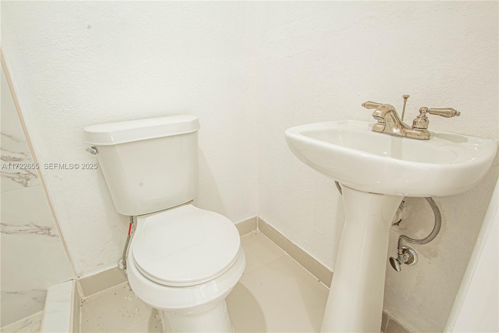 575 Northwest 49th Street Miami, FL 33127 - Photo 16 of 22 a bathroom with a toilet sink and mirror