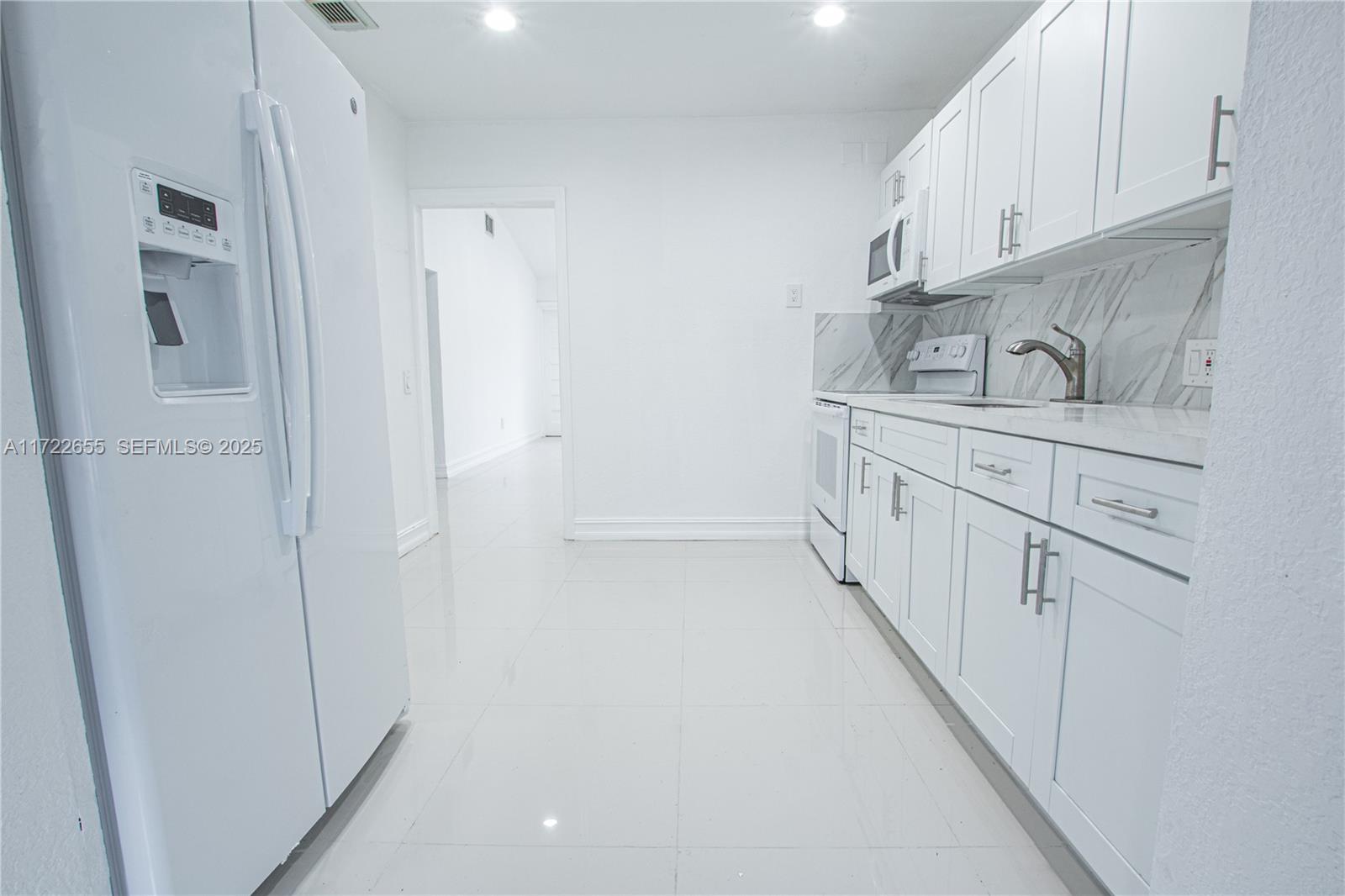 575 Northwest 49th Street Miami, FL 33127 - Photo 5 of 22 a kitchen with white cabinets