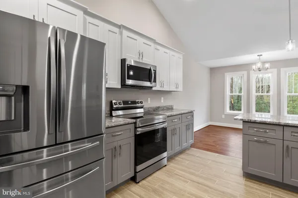 a kitchen with stainless steel appliances a refrigerator stove and microwave