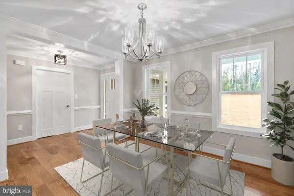 a living room with dining table and a chandelier