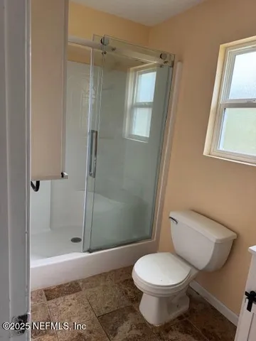 a bathroom with a toilet and a shower