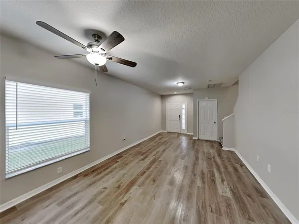 a view of empty room with wooden floor