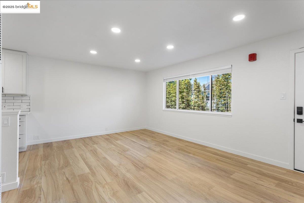 1610 Milvia Street Berkeley, CA 94709 - Photo 10 of 24 an empty room with wooden floor and windows