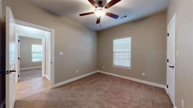 an empty room with fan and windows