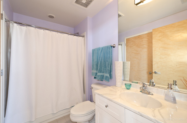 1201 West Adams Street, Unit 905 Chicago, IL 60607 - Photo 15 of 19 a bathroom with a granite countertop sink a toilet and a large mirror