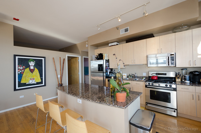 1201 West Adams Street, Unit 905 Chicago, IL 60607 - Photo 3 of 19 a kitchen with stainless steel appliances granite countertop a refrigerator a stove and a sink with wooden floor