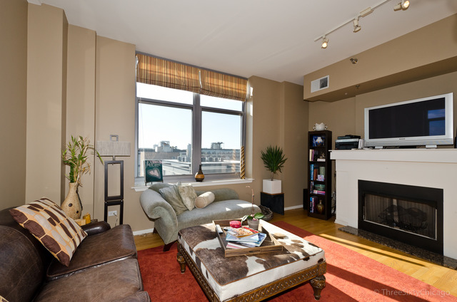 1201 West Adams Street, Unit 905 Chicago, IL 60607 - Photo 8 of 19 a living room with furniture a flat screen tv and a fireplace
