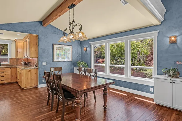 a kitchen island with granite countertop a table and chairs in it