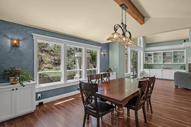 a kitchen with stainless steel appliances granite countertop a table chairs stove and refrigerator