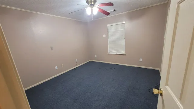an empty room with a ceiling fan and window