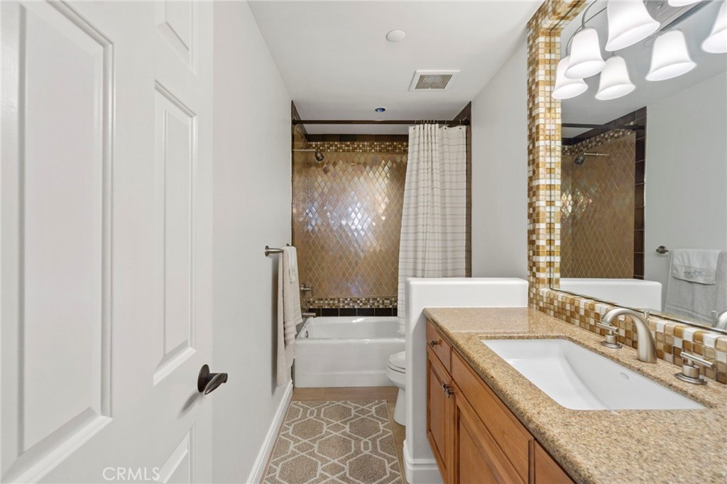 34403 Street Of The Green Lantern, Unit 2 Dana Point, CA 92629 - Photo 29 of 38 a bathroom with a granite countertop sink a mirror and a shower