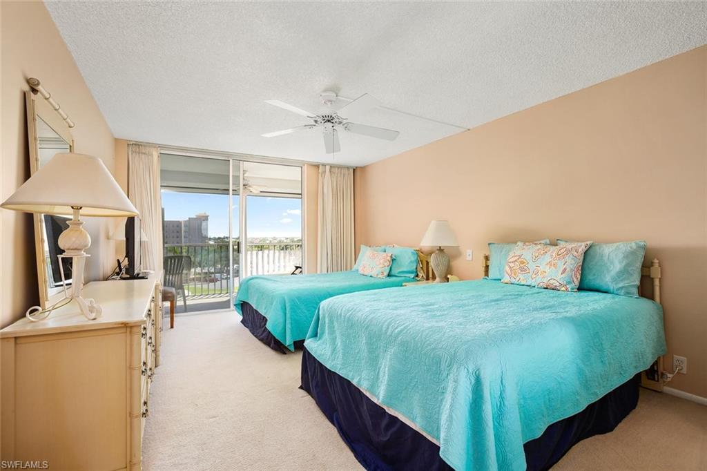 3 Bluebill Avenue, Unit 610 Naples, FL 34108 - Photo 11 of 15 a bedroom with a bed and a chandelier