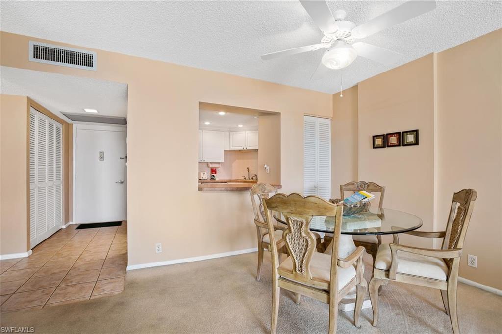 3 Bluebill Avenue, Unit 610 Naples, FL 34108 - Photo 5 of 15 a view of a dining room with furniture and a chandelier fan
