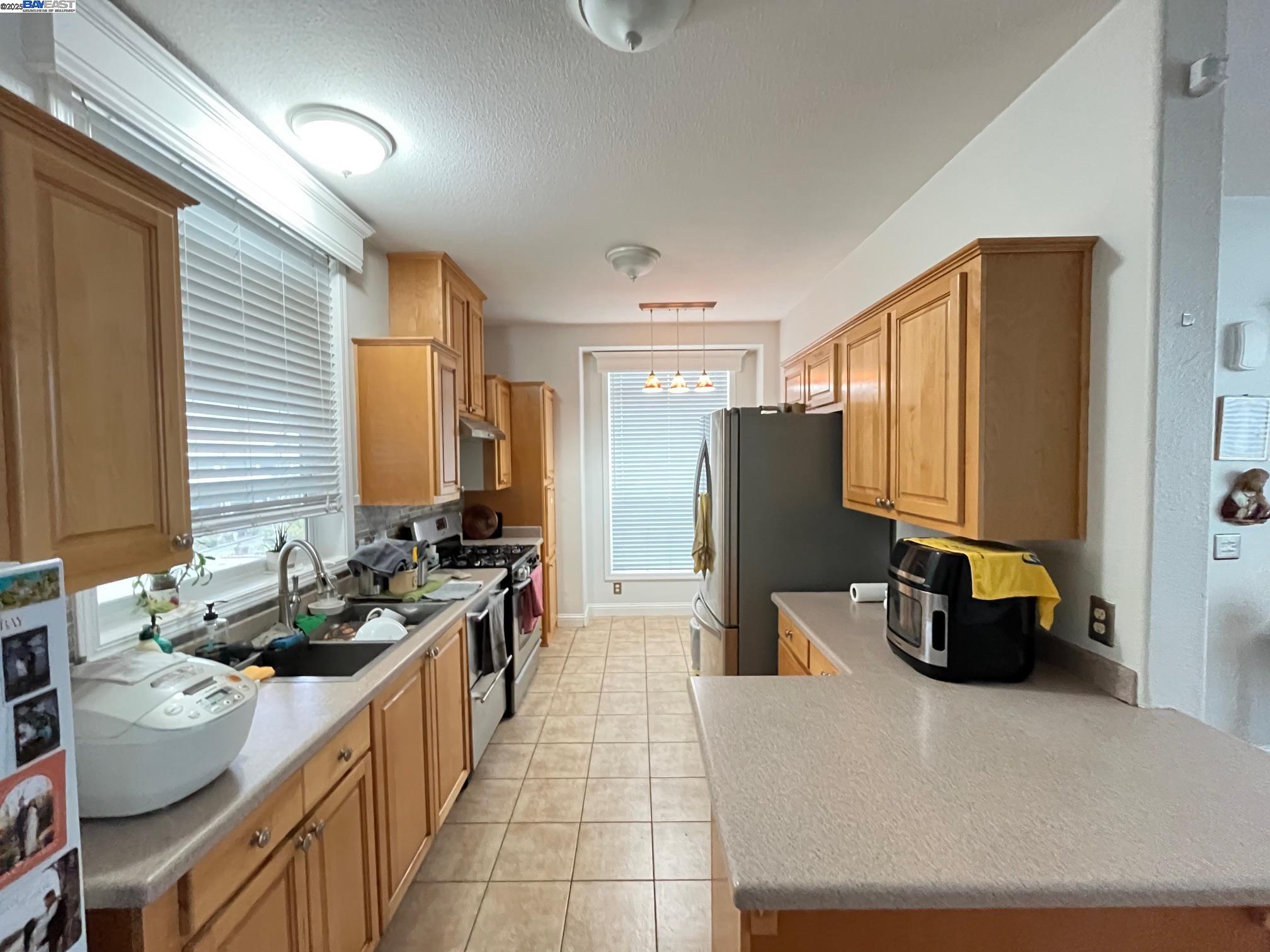 29043 Windemere Road Hayward, CA 94544 - Photo 3 of 8 a kitchen with stainless steel appliances a stove top oven and a refrigerator