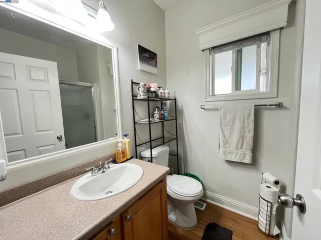 a bathroom with a sink vanity granite and toilet