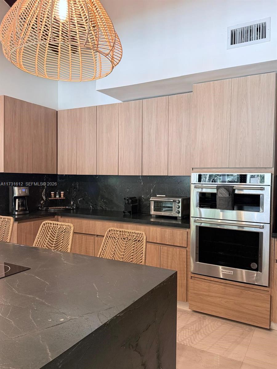 14875 Southwest 212th Street Miami, FL 33187 - Photo 40 of 80 a kitchen with stainless steel appliances a stove a microwave and a view of living room