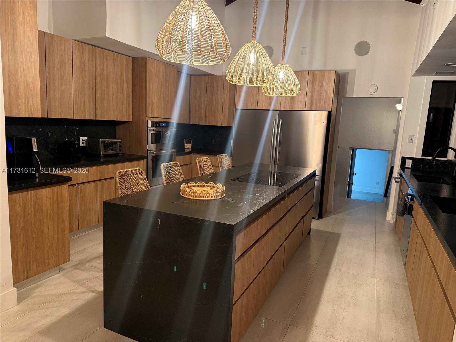 14875 Southwest 212th Street Miami, FL 33187 - Photo 46 of 80 a kitchen with stainless steel appliances kitchen island granite countertop a table chairs and a refrigerator