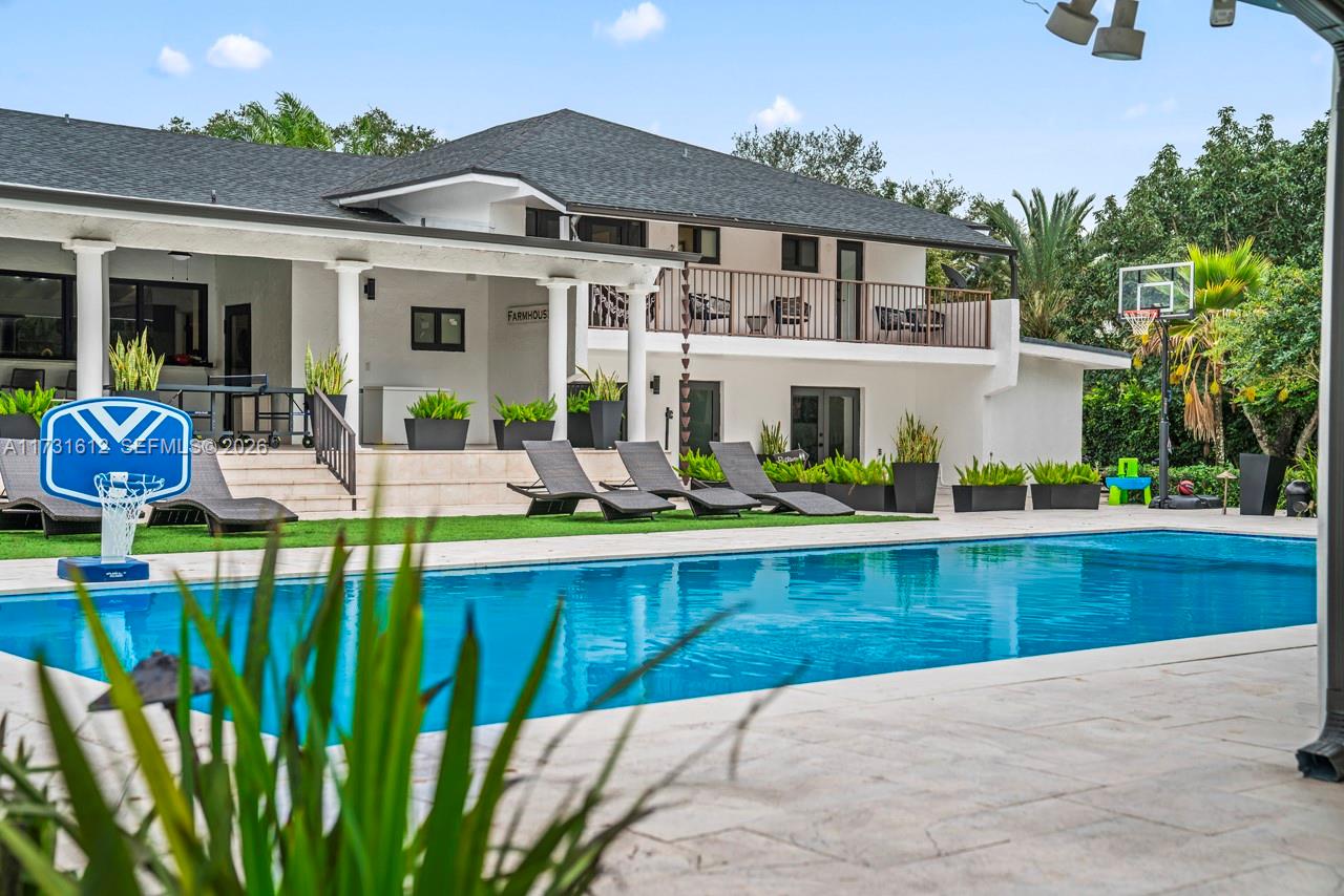14875 Southwest 212th Street Miami, FL 33187 - Photo 6 of 80 a view of swimming pool with outdoor seating and a garden