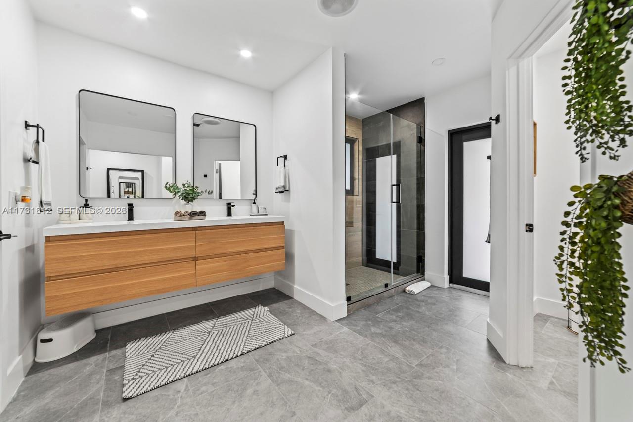 14875 Southwest 212th Street Miami, FL 33187 - Photo 74 of 80 a bathroom with a double vanity sink and a mirror