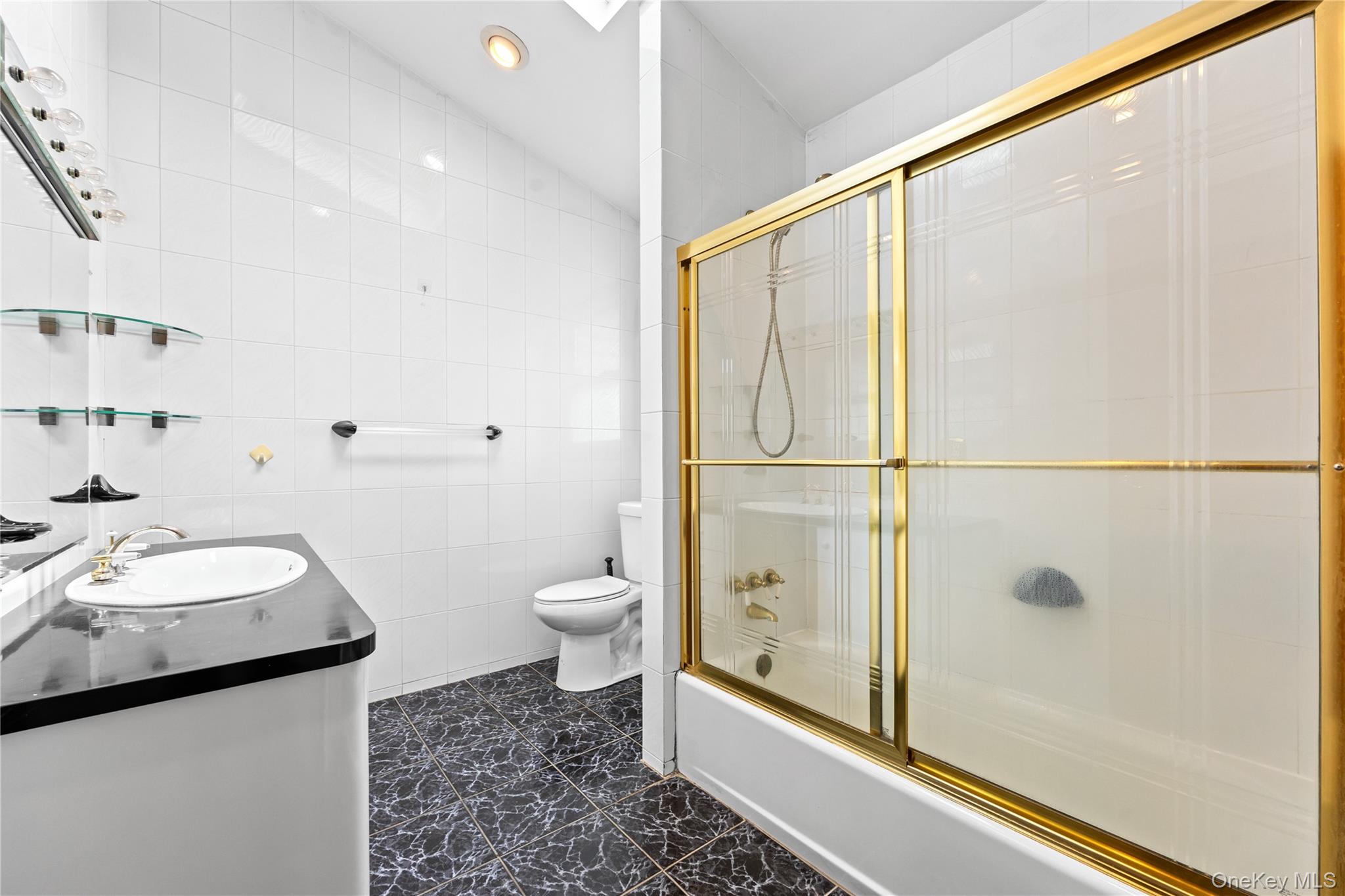 42-25 189th Street Queens, NY 11358 - Photo 12 of 25 a bathroom with a granite countertop sink toilet and shower