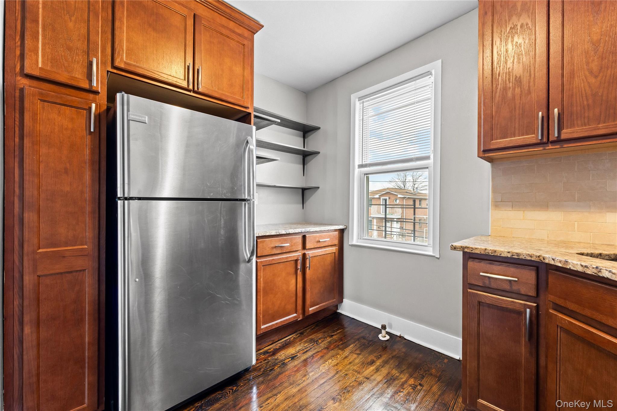 42-25 189th Street Queens, NY 11358 - Photo 14 of 25 a kitchen with stainless steel appliances granite countertop a refrigerator a microwave oven cabinets and a refrigerator