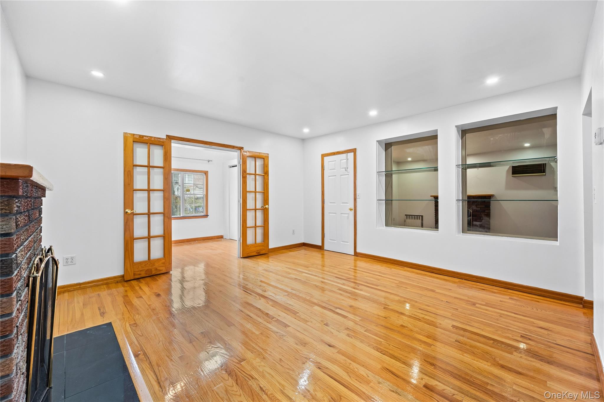 42-25 189th Street Queens, NY 11358 - Photo 5 of 25 a view of an empty room with wooden floor and a window