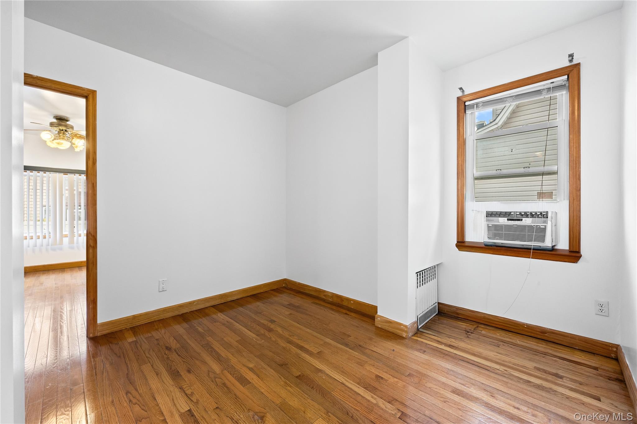 42-25 189th Street Queens, NY 11358 - Photo 9 of 25 a view of empty room with wooden floor and fan
