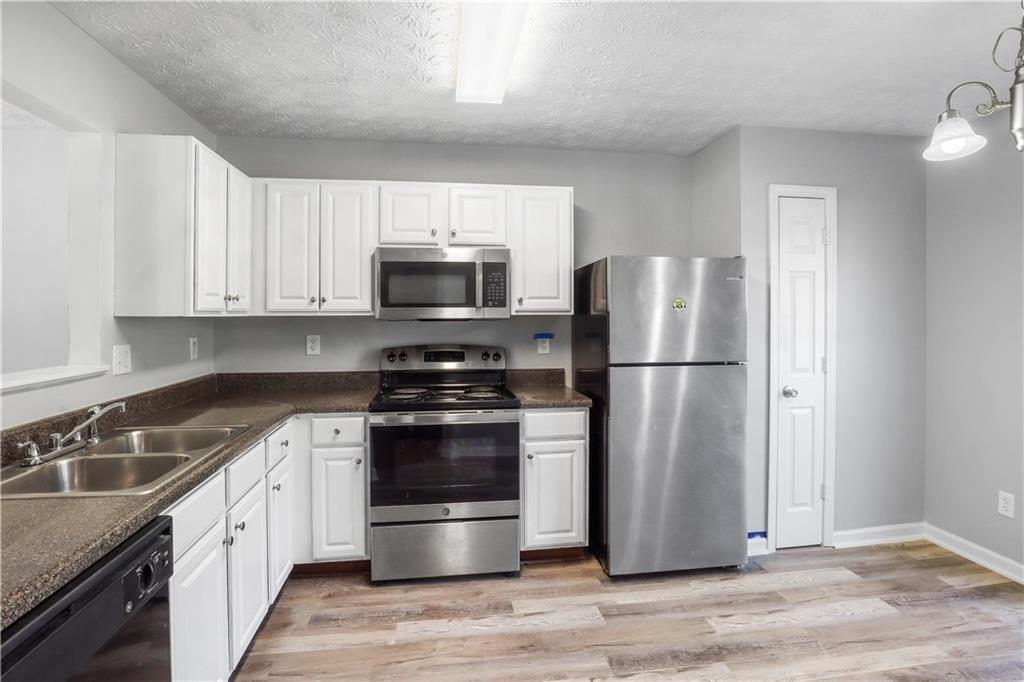 3882 Waldrop Lane Decatur, GA 30034 - Photo 3 of 11 a kitchen with wooden cabinets stainless steel appliances and a sink