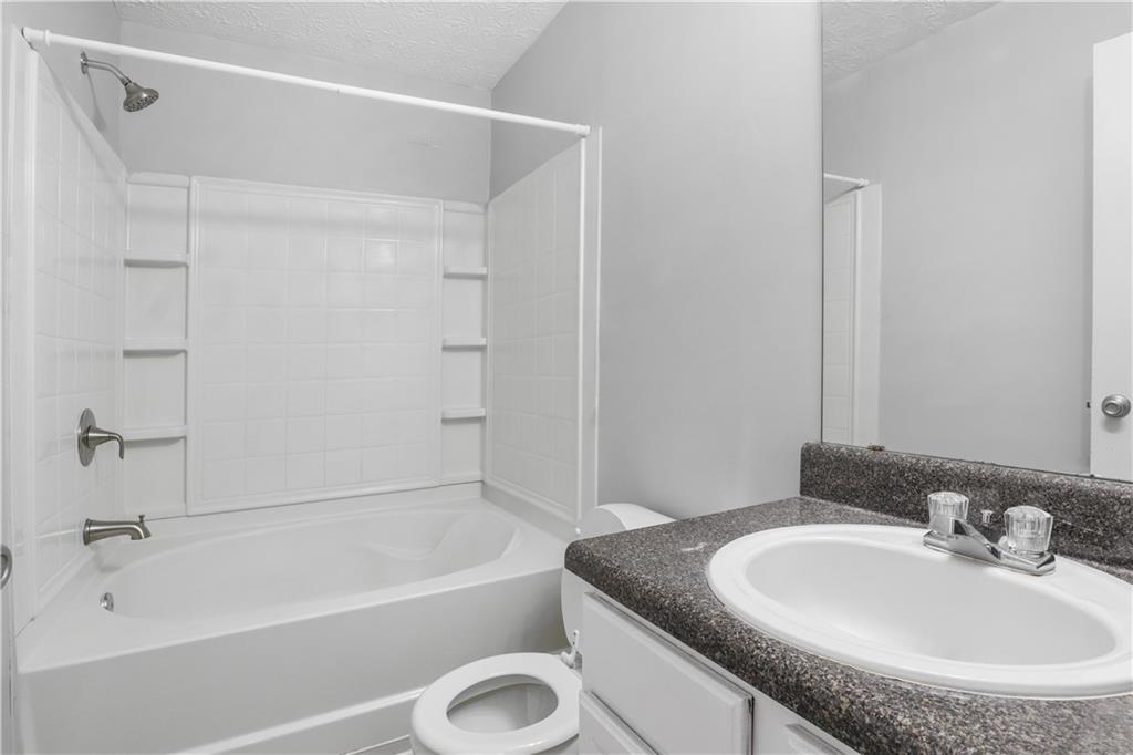 3882 Waldrop Lane Decatur, GA 30034 - Photo 9 of 11 a bathroom with a granite countertop sink a mirror and a bathtub