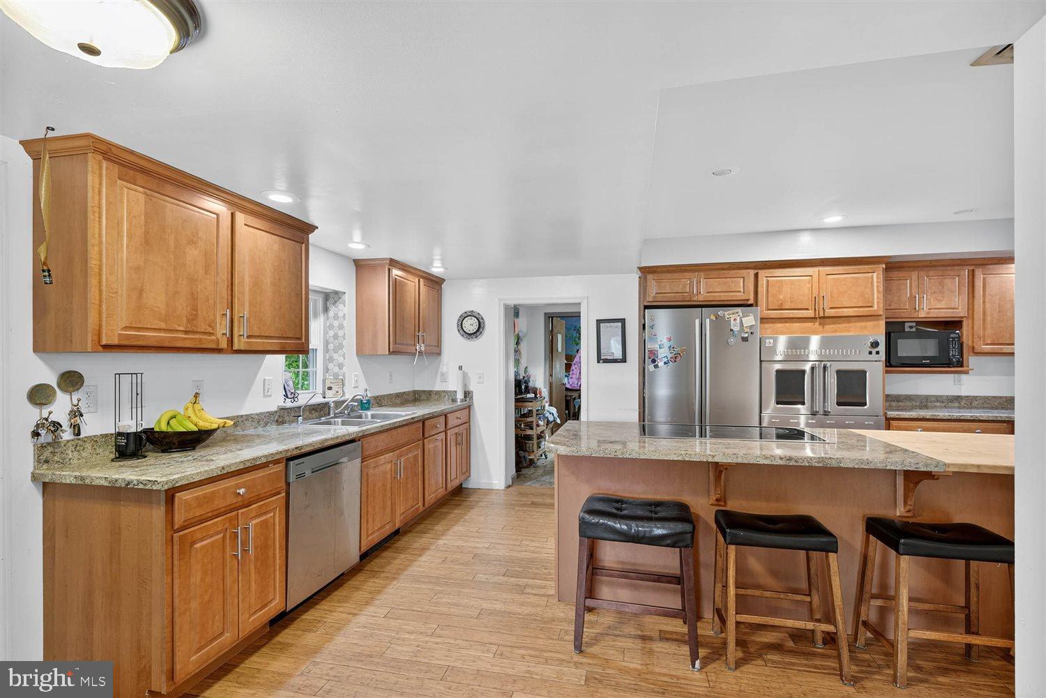 5987 River Road Conestoga, PA 17516 - Photo 13 of 40 a kitchen with stainless steel appliances granite countertop wooden cabinets a table and chairs