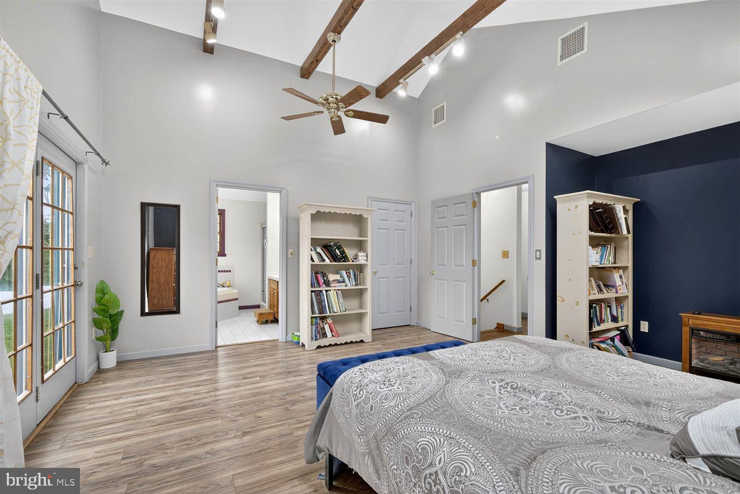 5987 River Road Conestoga, PA 17516 - Photo 23 of 40 a spacious bedroom with a bed and a dresser with wooden floor